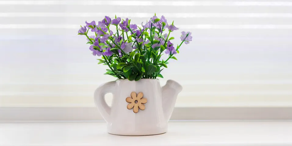 Purple flowers in a vase by a window
